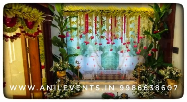 Anil Events Bangalore offer personalized decor solutions for Traditional decorations, Transform your new home into a haven of beauty with Mango leaf toran entrance decor has been enhanced by flowers, and simple rangoli and with traditional Backdrop.